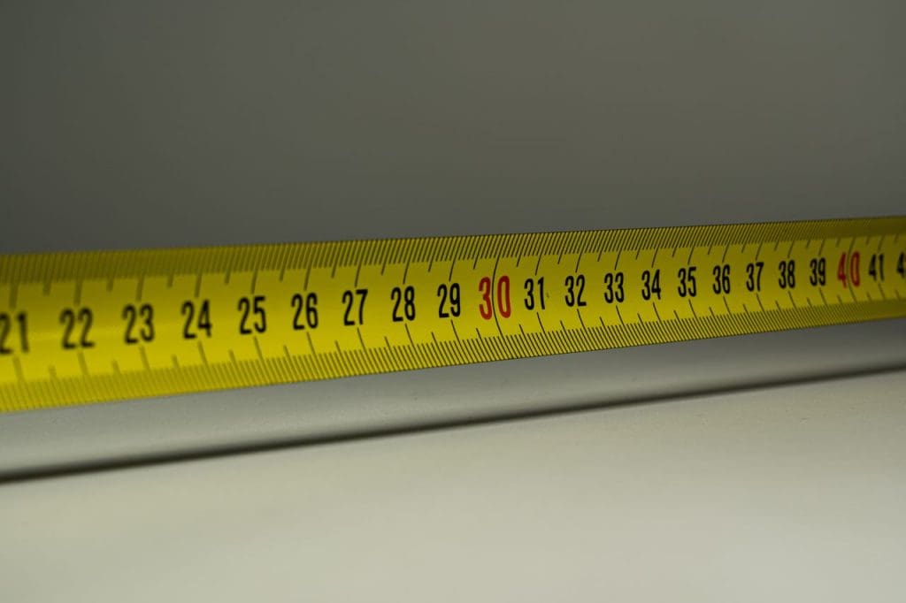 Close-up view of a yellow measuring tape with centimeter marks, emphasizing precision in measurement.